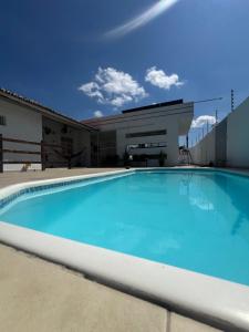 a large blue swimming pool in front of a building at Casa Mandaçaia in Piranhas