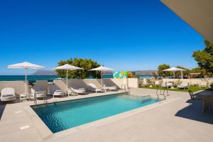 a swimming pool with chairs and umbrellas at Sal hotel Kissamos in Kissamos