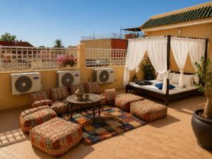 a patio with a bed and furniture on a balcony at Riad Zyna in Meknès