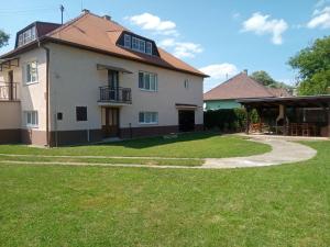 a large white house with a grass yard at Vidiecky dom in Veľký Krtíš