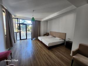 a bedroom with a bed and a large window at Belgrad Rustaveli Kobuleti in Kobuleti