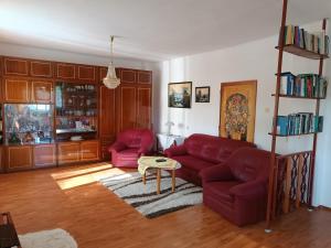 a living room with a red couch and a table at Vidiecky dom in Veľký Krtíš
