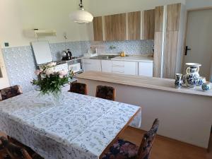 a kitchen with a table with a vase of flowers on it at Vidiecky dom in Veľký Krtíš