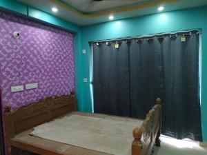 a room with purple walls and black shower curtains at North Grande in kolkata