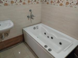 a bathroom with a bath tub and a sink at North Grande in kolkata
