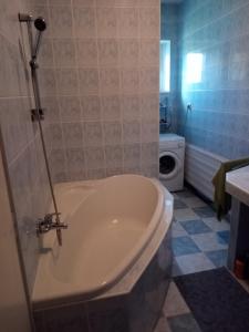 a bathroom with a tub and a toilet and a sink at Vidiecky dom in Veľký Krtíš +3 photos