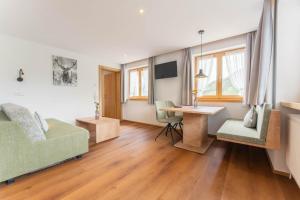 a living room with a bed and a desk at Hotel Hertehof in Damuls