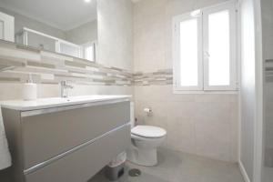 a white bathroom with a toilet and a sink at Alba Solis in Vejer de la Frontera +12 photos