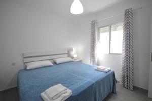 a bedroom with a blue bed with two towels on it at Alba Solis in Vejer de la Frontera