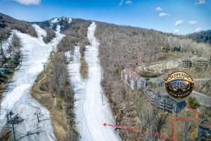 an aerial view of a snow covered mountain with a ski slope at Slopeside Lodge at Sugar Mountain in Sugar Mountain