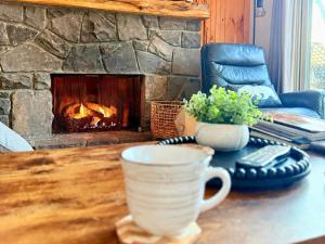 a coffee cup sitting on a table in front of a fireplace at Slopeside Lodge at Sugar Mountain in Sugar Mountain
