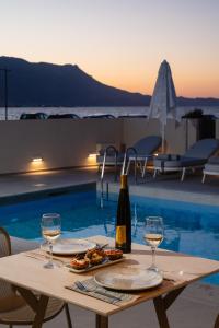 a table with two glasses of wine and food at Sal hotel Kissamos in Kissamos