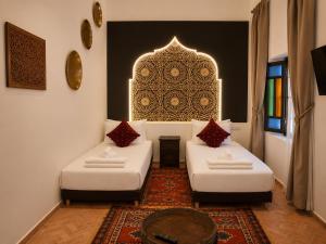 a living room with two beds and a table at Riad Zyna in Meknès