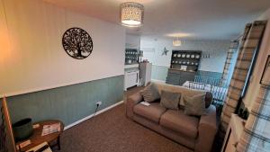 a living room with a couch and a kitchen at Oak Bungalow in Carbis Bay +7 photos