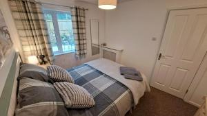a bedroom with a bed with pillows and a window at Oak Bungalow in Carbis Bay
