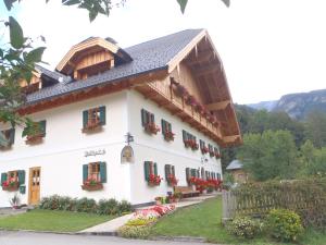 ein weißes Gebäude mit Blumen an den Fenstern in der Unterkunft Russbachbauer in St. Wolfgang