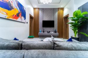 a living room with a couch and a tv at One90 Apartment in Lagos