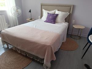 a bedroom with a large bed with a purple pillow at Mon Petit Château Grand appartement de 120 m2 in Pajay