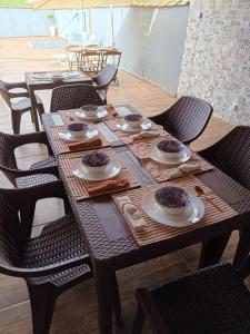 a wooden table with chairs and plates of food on it at Pousada Fernandes in Três Corações