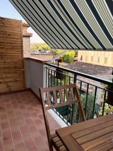 a balcony with a wooden table and a bench at Aperto Tuscany apartment in Torrenieri