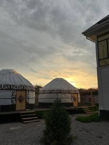two gazebos in a yard next to a building at Yurt house in Tong