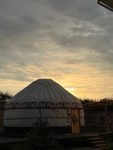 a large dome tent with a sunset in the background at Yurt house in Tong