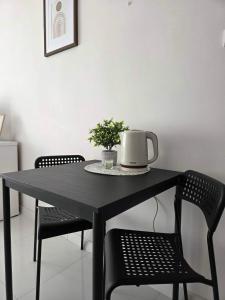 a black table with two chairs and a pot on it at Apartament Mostowa in Brodnica +2 photos