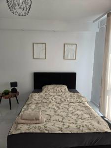 a large bed in a white room with a bedspread at Apartament Mostowa in Brodnica