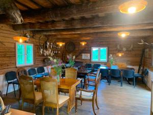 a dining room with wooden walls and tables and chairs at Jõesuu saunamaja in Valga