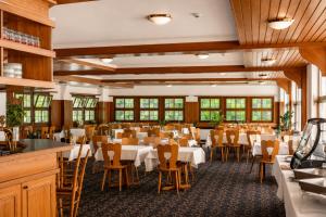 a dining room with white tables and chairs at Seehotel Schwert in Gersau