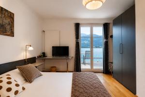 a bedroom with a bed and a desk with a television at Seehotel Schwert in Gersau