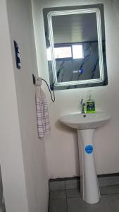 a bathroom with a white sink and a mirror at Little Home in General Viejo