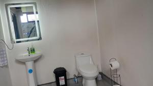a white bathroom with a toilet and a sink at Little Home in General Viejo
