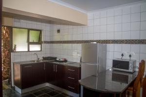 a kitchen with a stainless steel refrigerator and a sink at Areena Riverside Resort in Kwelera