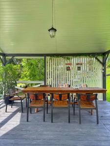 a wooden table and benches under a green canopy at Jaki tu spokój Domek w Bieszczadach in Wojtkowa
