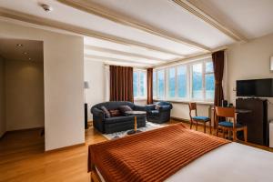 a bedroom with a king sized bed and a living room at Seehotel Schwert in Gersau