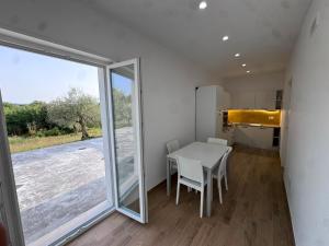 a dining room with a table and a large window at Les chambres de Nancy in Contursi Terme