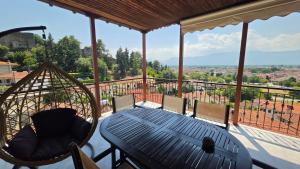 a porch with a table and chairs on a balcony at Villa Hill in Tríkala