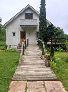 a wooden walkway leading to a white building at Valiant B&B in Otterbäcken