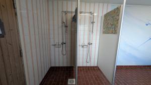 a shower in a bathroom with a tiled floor at Höghedens camping in Älvsbyn +18 photos