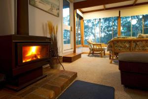 a living room with a fireplace and a couch at Seascapes at Rosedale in Tomakin +22 photos
