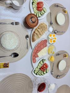 a white table with plates of food on it at Crown Inn & Spa in Karakol