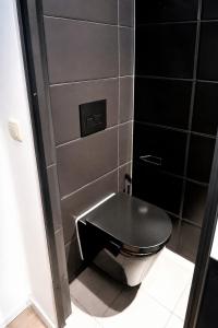 a black toilet with a black seat in a bathroom at Der Sunderhof in Seevetal