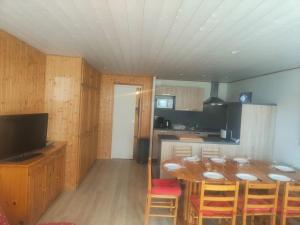 a dining room with a table and a kitchen at Evasion in Orcières