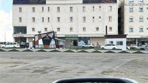 a view of a street with a building with cars parked at أرياف سويت in Al Baha
