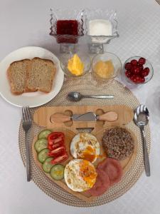 a plate of breakfast food with eggs bread and other foods at Crown Inn & Spa in Karakol