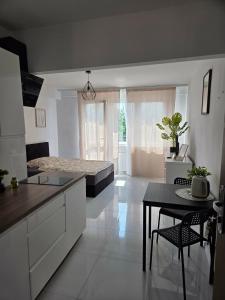 a kitchen with white cabinets and a table and a dining room at Apartament Mostowa in Brodnica