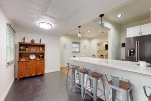 a kitchen with a long bar with stools at Easy Access to OSU! 'Marvin's Manor' in Stillwater in Stillwater