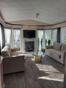 a living room with two couches and a fireplace at Camping La Tentation in Renty