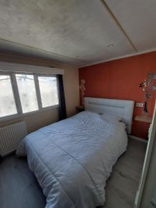 a bedroom with a large bed with orange walls at Camping La Tentation in Renty